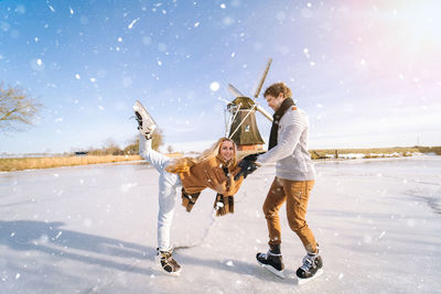 Full length of young couple on snow