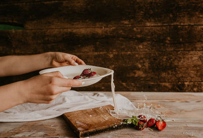 Cropped image of man holding food on table