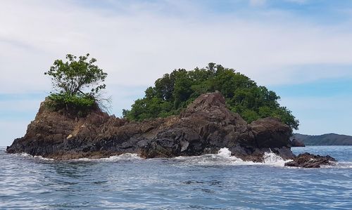 Rock formation in sea against sky