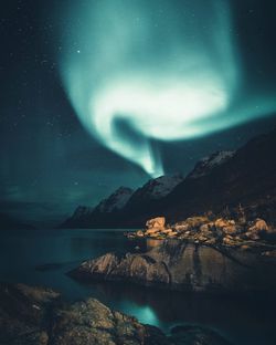 Scenic view of sea against aurora borealis at night