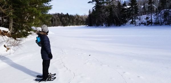 Side view of person standing on snow field
