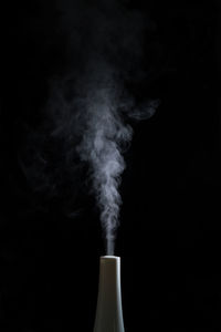 Close-up of smoke emitting over black background