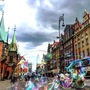 City street in front of buildings against cloudy sky