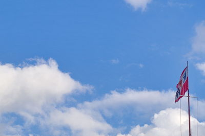 Low angle view of flag against blue sky