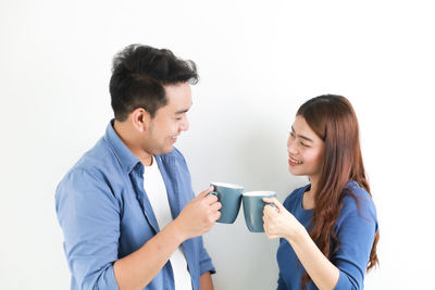 Young couple standing against white background