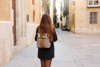 Rear view of woman walking on street in city