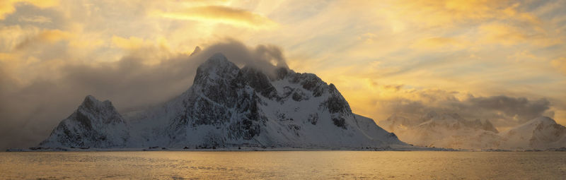 Scenic view of sea and mountains against sky during sunset