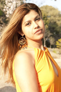 Portrait of young woman yellow dress on sunny day