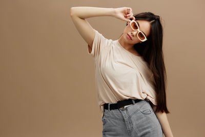 Portrait of young woman standing against wall