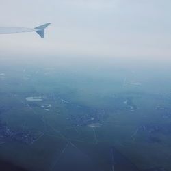 Aerial view of airplane wing over sea