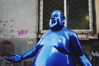 Close-up of blue statue against building