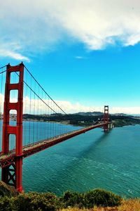 Bridge over sea against cloudy sky