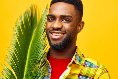 Portrait of young man against yellow background