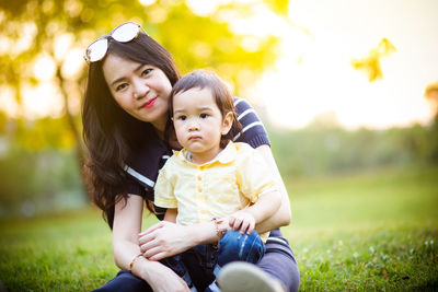 Mother and her boy sitting outdoors