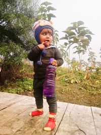 Full length of girl standing against plants