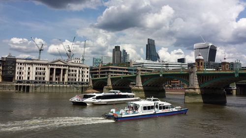 Boats in city against sky