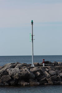 Lighthouse on beach against sky