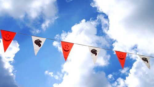 Low angle view of flags hanging against sky