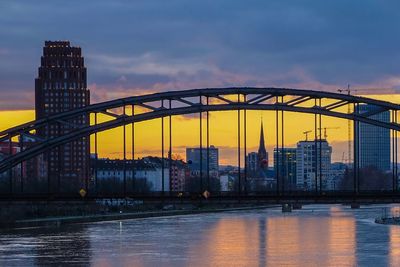 View of suspension bridge in city at sunset