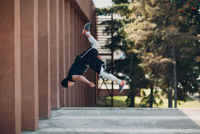 Side view of man jumping in city