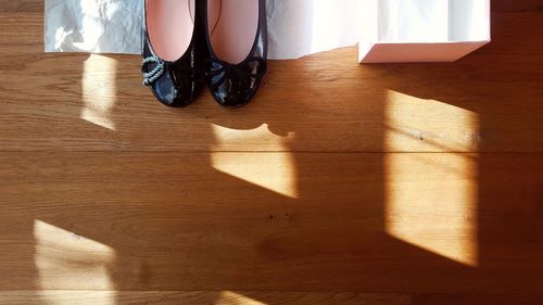 Low section of woman sitting on hardwood floor