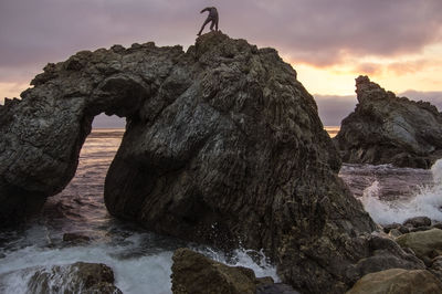 Woman standing on rock formation at big sur