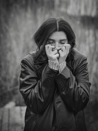 Portrait of young woman with eyes closed standing outdoors