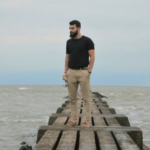 Young man looking at sea against sky