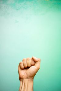 Close-up of hand against blue background