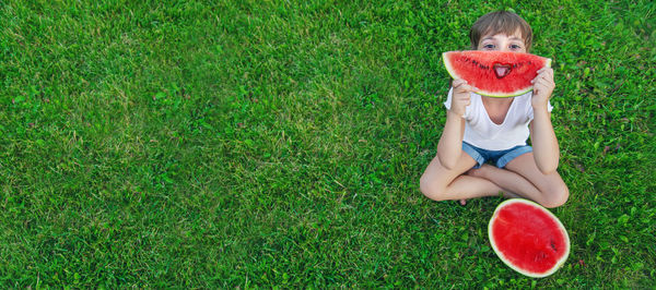 High angle view of cute girl playing with teddy bear on grassy field