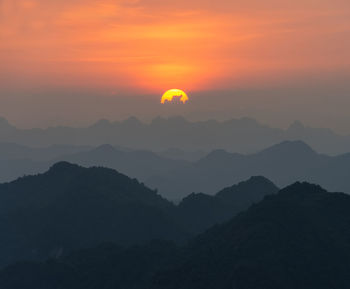 Scenic view of silhouette mountains against romantic sky at sunset