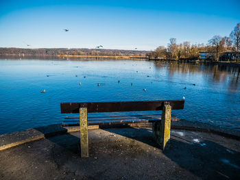 Pier on lake against blue sky