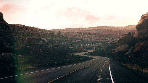 Road leading towards mountain against sky