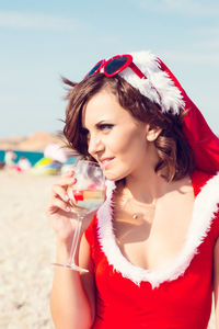 Beautiful young woman drinking water from beach