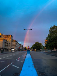 Rainbow road. city street against sky at dusk