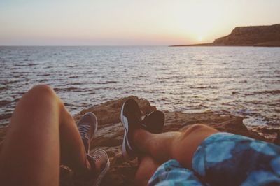 Low section of man relaxing on beach