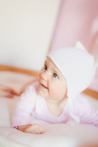 Portrait of baby girl on bed at home