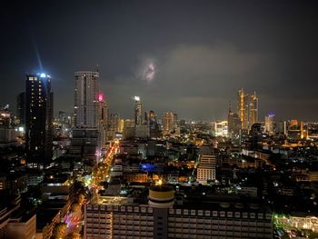 Illuminated buildings in city against sky at night