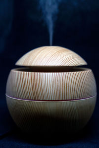 Close-up of illuminated lighting equipment on table against black background