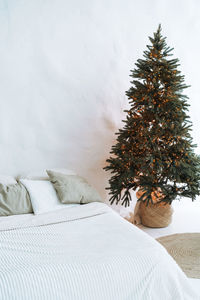 Decorated christmas tree at bedroom in eco bright interior at home