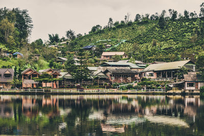 Scenic view of lake by buildings against sky