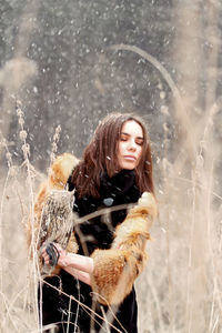 Young woman smiling while standing in snow