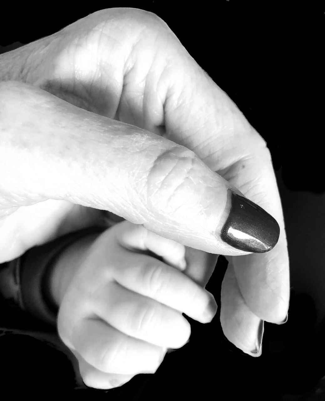 CLOSE-UP OF A HAND HOLDING A BABY