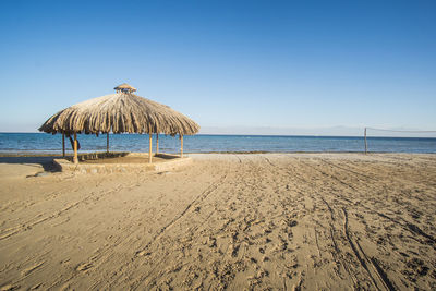 Deck chairs on beach against clear sky