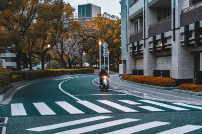 Man walking on street amidst buildings in city