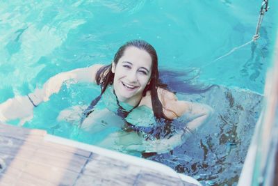 Portrait of a smiling young woman swimming in pool