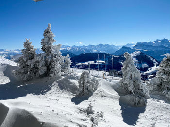 Scenic view of snowcapped mountains against clear blue sky