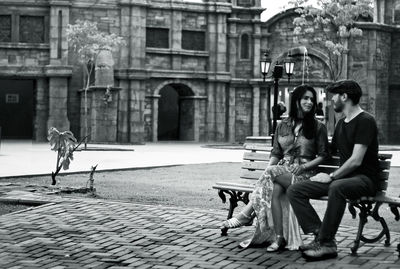 Young woman sitting in front of building