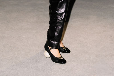 Low section of woman standing on road