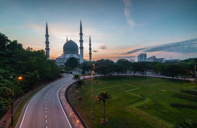 Sultan salahuddin abdul aziz mosque in city against sky during sunset